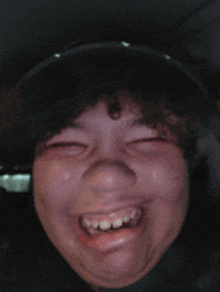 a close up of a person 's face with a big smile