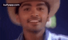 a man wearing a cowboy hat is smiling .