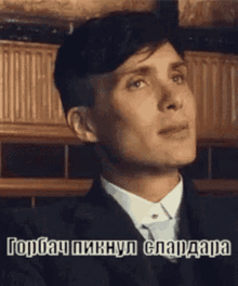 a man in a suit and tie is looking up with a caption in foreign language