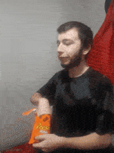 a man in a black shirt holds a bag of reese 's minis