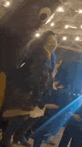 a group of people are dancing in a dark room with lights .