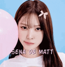 a close up of a girl holding a pink balloon in her hand .