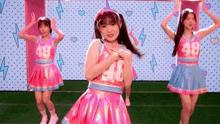 a girl in a pink dress has the number 48 on her top