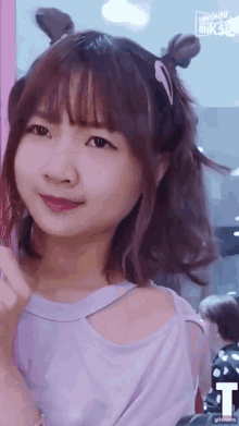 a girl with a bun in her hair looks at the camera with a gif.com logo behind her