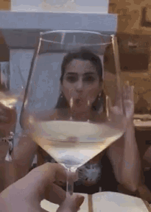 a woman is drinking from a wine glass with her mouth wide open