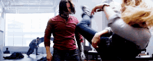 a man in a red shirt is kicking a woman