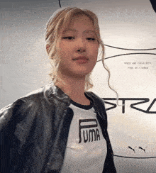 a woman wearing a puma t-shirt and a black jacket