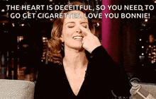 a woman is sitting on a couch with her hand on her nose and a quote .