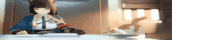 a girl is sitting at a table with a cat on the table .