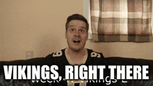 a man is sitting on a couch with the words vikings right there above him