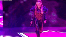 a pixelated image of a woman walking on a stage with a purple background