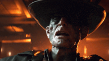 a close up of a man wearing a cowboy hat and a black jacket