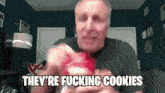 a man is eating a cookie and saying they 're fucking cookies .