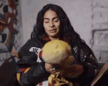 a woman is holding a stuffed animal in her hands and making a face .