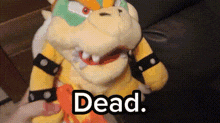 a person is holding a stuffed animal with the word dead written on it .