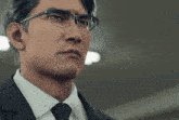 a man in a suit and tie with glasses on