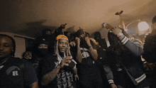a group of men wearing black shirts with the letter r on them are dancing