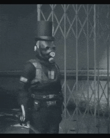 a black and white photo of a man wearing a top hat with the word police on his arm