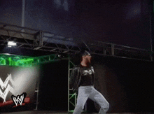 a wrestler is standing on a stage in front of a green screen
