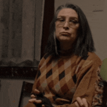 a woman wearing glasses and a plaid sweater