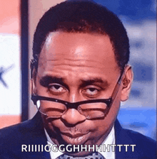 a man wearing glasses and a suit is making a funny face