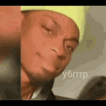 a close up of a person wearing a neon green hat making a funny face .