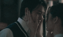a man is hugging a woman in a dark room .