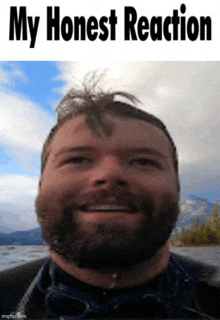 a man with a beard is smiling with the words my honest reaction behind him