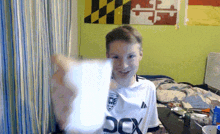 a boy wearing a white shirt that says box on it