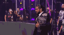 a man in a suit is holding a world heavyweight wrestling championship