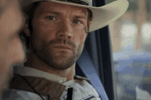 a man wearing a cowboy hat has a patch on his face