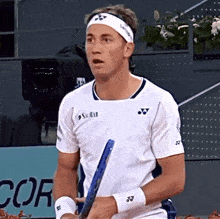 a tennis player wearing a white shirt that says yonex on the front