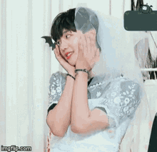 a man dressed as a bride with a veil on his head is laughing .