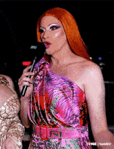 a woman in a pink dress is holding a microphone that says rode