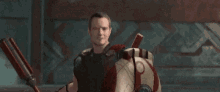 a man is holding a red and white shield and a spear in a video game