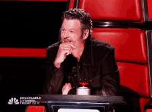 a man is sitting in a chair with his hand on his chin and the words " undateable " on the bottom left