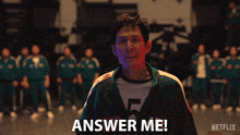 a man screaming in front of a group of people with the words answer me