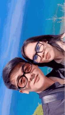 a man and a woman wearing glasses and sunglasses pose for a picture