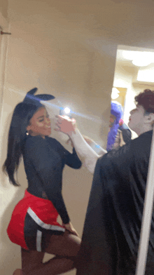 a woman in bunny ears is taking a picture of herself in a mirror