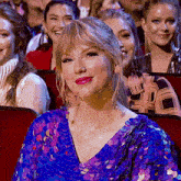 a woman in a blue sequined dress is smiling