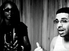 a black and white photo of two men wearing sunglasses