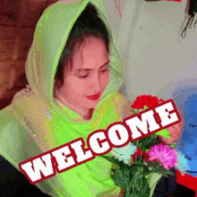 a woman in a green scarf is holding a bouquet of flowers with the words welcome written on the bottom