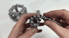 a person holding a bunch of metal beads in their hands