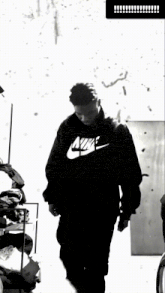 a black and white photo of a person wearing a nike sweatshirt