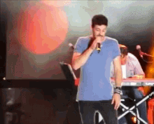 a man is singing into a microphone on a stage