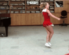 a cheerleader in a red and white outfit is dancing