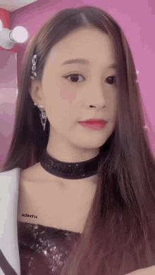 a woman wearing a choker and earrings has a tattoo on her chest