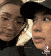 two women wearing glasses and hats are looking at the camera .