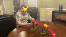a man wearing a pikachu mask and sunglasses is playing a game