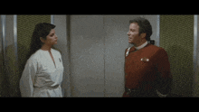 a man in a red uniform and a woman in a white shirt are standing next to each other